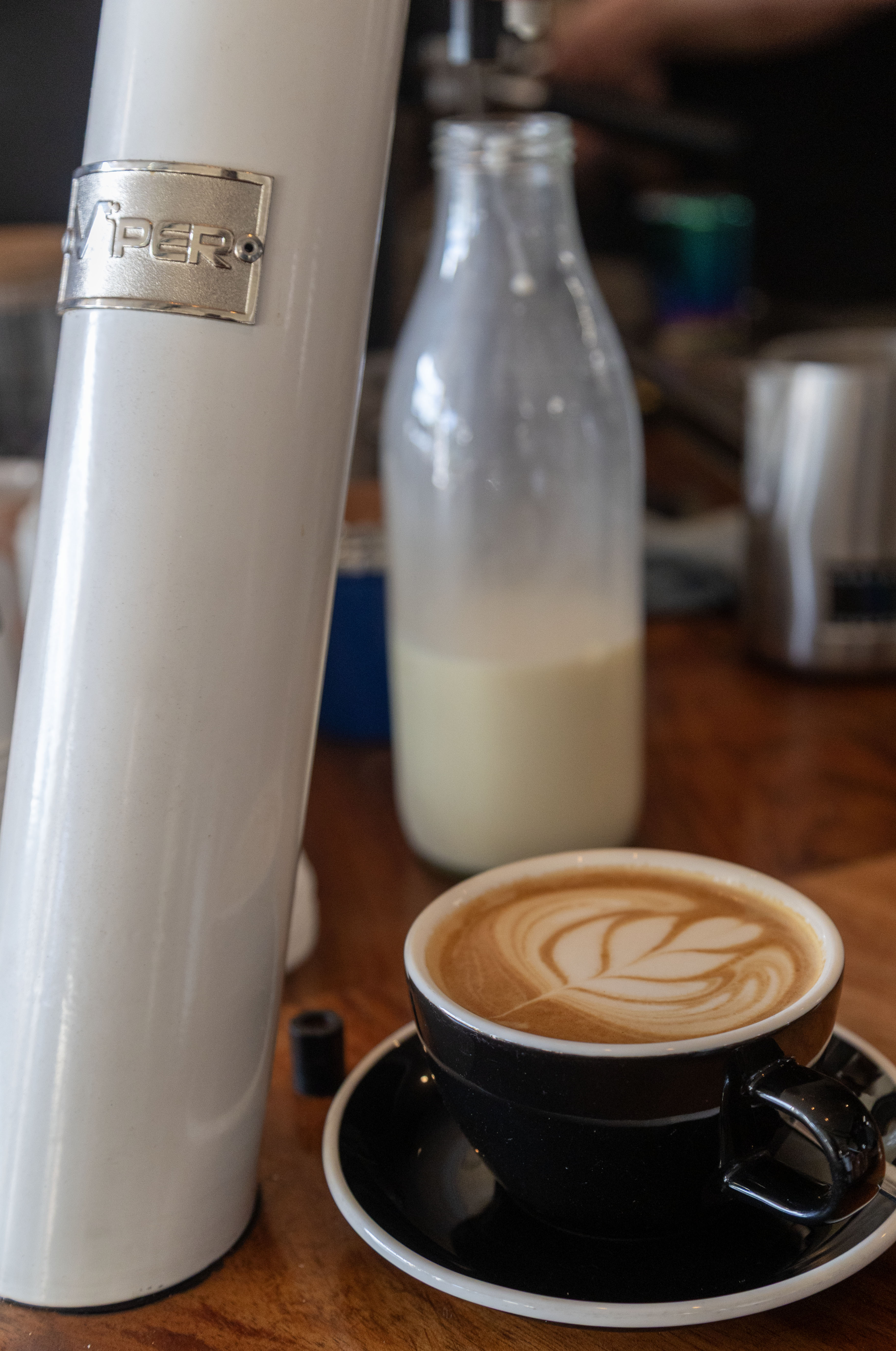 Fresh milk TUW keg at a café next to a latte